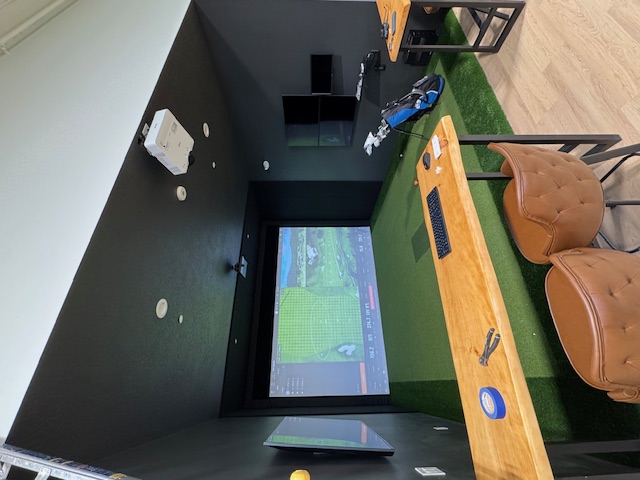 Golf simulator AV room with projector and display equipment
